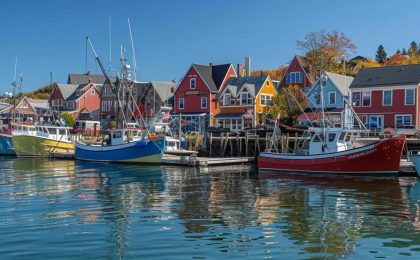 a vibrant, bustling marina scene in bar harbor, maine, featuring colorful charter boats docked against a backdrop of charming coastal buildings and a clear blue sky, embodying the spirit of maritime adventure.